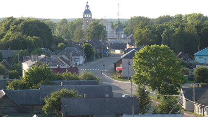 Quiet village street with historical church in the distance during golden hour light