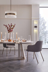 Vertical view of a luxurious dining room set for Christmas. Modern interior with festive table and snowy winter window.