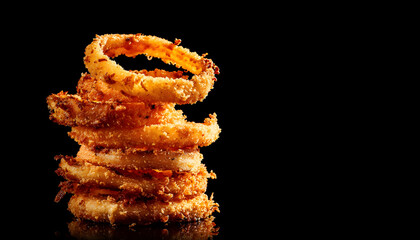 Rotating Pile of Crispy Fried Onion Rings on Black Background
