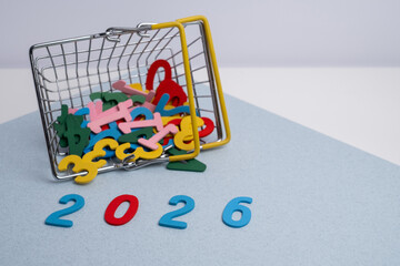 Planning goals for 2026: miniature shopping basket spilling out colorful letters and numbers on a pastel background.