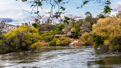Serene river scene with autumn foliage rustic bridge. Tranquil landscape, golden hour light, nature beauty. Perfect for relaxation or travel themes.