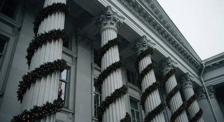 Classical building facade with festive holiday decorations. Architectural columns wrapped in glowing Christmas garlands. Winter cityscape with snowfall and seasonal decor. Urban celebration