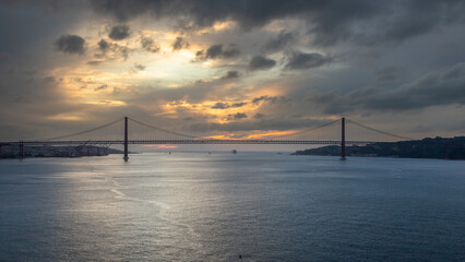 Panoramic Exposure done from a Cruise ship, while arriving at Lisbon at sunrise, of the 25th April Bridge and Tagus River, with Lisbon on the left bank and the Sanctuary of Christ the King, Portugal