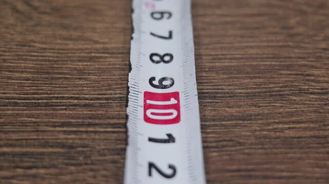 Close-up of a tape measure laid on a wooden surface