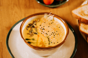 Creamy soup with toppings served on a rustic wooden table