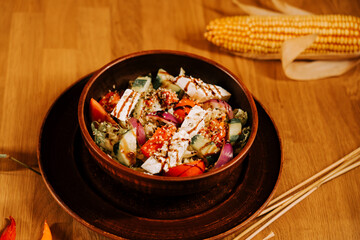 Colorful salad bowl with grilled vegetables and cheese served on wooden table
