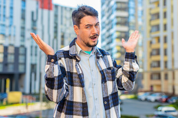 Doubtful sad frustrated mature man tourist shrugging shoulders dont know answer incertitude gesture uncertain reaction on difficult question, confused guy millennial feel disappointment on city street