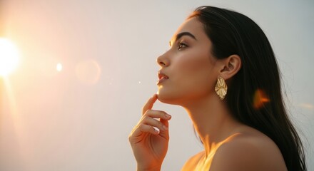 Beautiful female profile with glowing skin in golden sunlight. Luxury jewelry and skincare campaign. Young adult woman in a thoughtful pose. Natural beauty and wellness concept