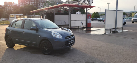 A clean car in front of a car-washing place
