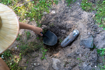 Find a bottle in the ground with a message from the past.A time capsule buried in the garden.