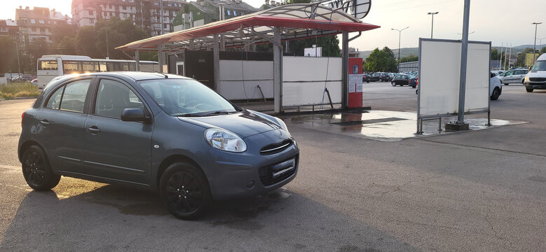 A clean car in front of a car-washing place