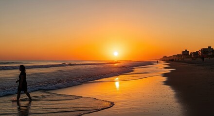 Adult female silhouette walking on a beach at sunset. Golden hour light reflecting on the ocean waves. Coastal travel destination for vacation. Wellness and mindful lifestyle concept