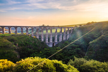 Aqueduct between mountains at sunrise with cloudy sky in arcos del sitio in tepotzotlan state of...