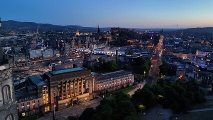 Dusk aerial view of Edinburgh Scotland showing illuminated architecture and traffic at night looking toward Edinburgh Castle