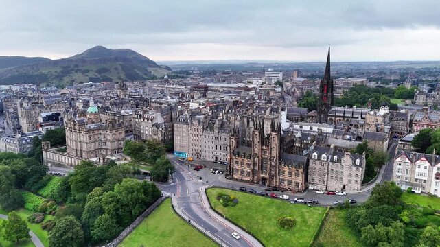 Aerial view of Edinburgh Scotland featuring Old Town architecture parks and Arthur's Seat in the background on an overcast day