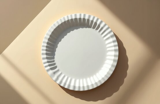 White fluted paper plate rests on a beige surface. Soft shadows create a minimalist composition perfect for food styling, picnics, or eco friendly events. Simple design, clean lines.
