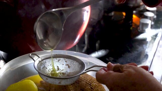 Slow motion. The cook, pours the broth over the chickpeas through a strainer.