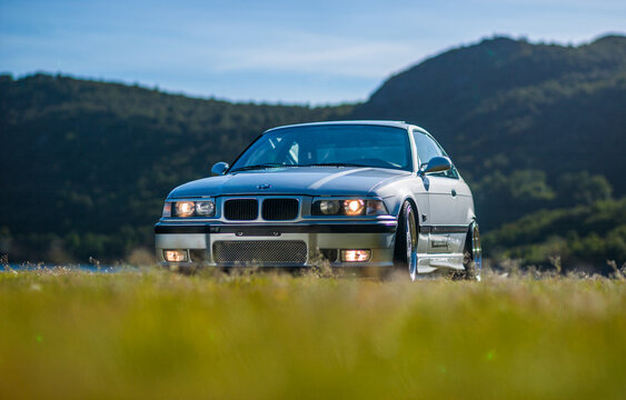 Lindesnes, Norway - August 16 2005: Stylish silver coupe parked on grass near water.