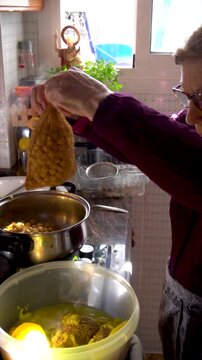 Slow motion, Grandmother cooking a traditional stew in the kitchen at home.