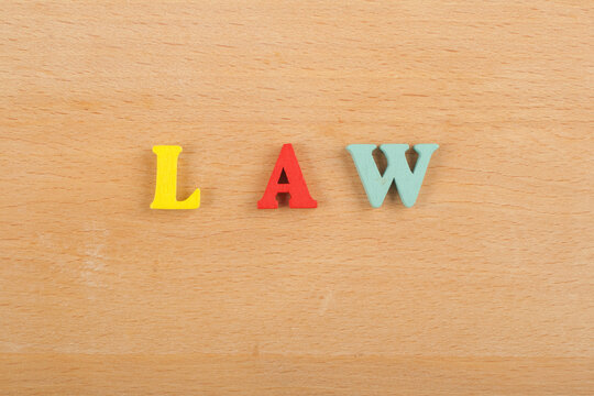 LAW word on wooden background composed from colorful abc alphabet block wooden letters, copy space for ad text. Learning english concept.