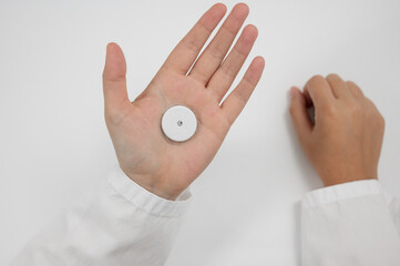 Person’s hand displaying a CGM wearable sensor for blood sugar monitoring