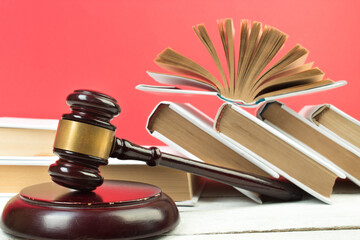 Law concept - Open law book, Judge's gavel, scales, Themis statue on table in a courtroom or law...