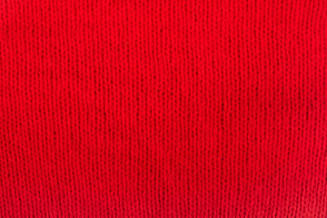Fototapeta premium Sweater or scarf fabric texture large knitting. Knitted jersey background with a relief pattern. Wool hand- machine, handmade. red.