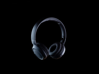 Headphones isolated on a black background. Black-on-black photography style.