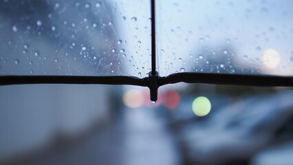 A transparent umbrella and a street out of focus, an autumn city in cloudy weather, melancholic bokeh