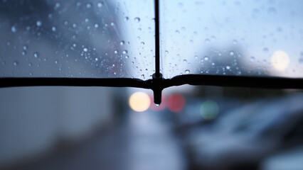 A transparent umbrella and a street out of focus, an autumn city in cloudy weather, melancholic bokeh