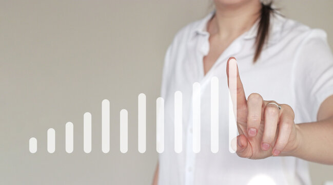Woman in white touching virtual ascending bar chart. Concept of growth, progress, business analytics, and success visualization. For illustrating financial improvement, innovation, and leadership