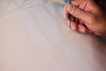 Closeup of technician testing automotive paint swatches with fine brush, Precision detailing...