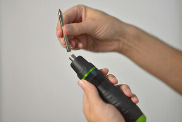 A man changing drill bit in electric screwdriver