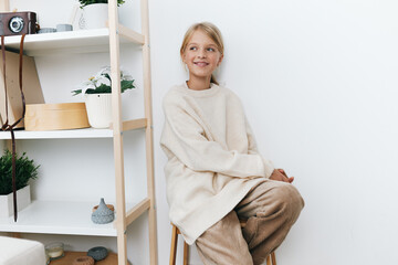 Authentic lifestyle portrait of a young student in a soft beige sweater, capturing simple comfort, casual charm, and quiet moments of everyday learning at home.
