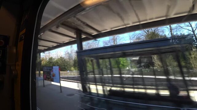 View from the window of a Swiss train. Passing Cham station. Switzerland.