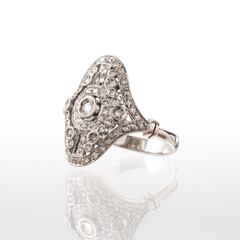 White gold ring with brilliant-cut diamonds isolated on a white background with reflections