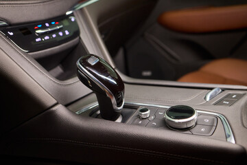 Automotive gear overview, Urban inspired vehicle interior showing gear shift and control features, Detailed shot of car gear selector with glossy knob and water droplets