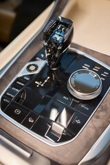 Automotive gear overview, Urban inspired vehicle interior showing gear shift and control features, Detailed shot of car gear selector with glossy knob and water droplets