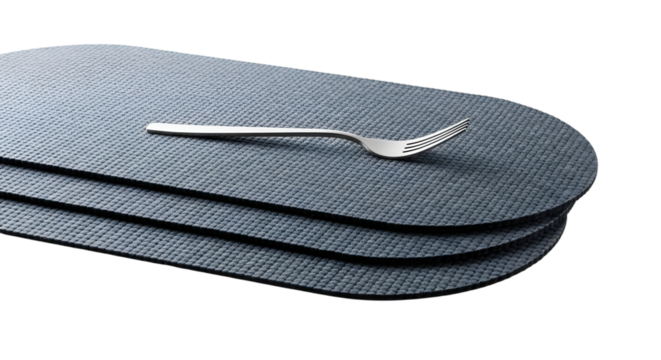 Stack of gray oval placemats with a silver fork isolated on transparent background