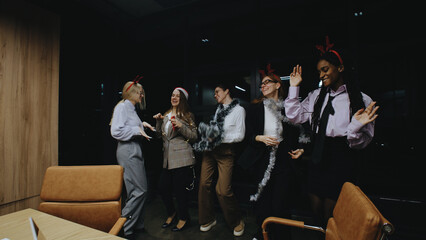 Business women celebrating together at work before the Christmas holiday with festive decorations and cheerful spirits