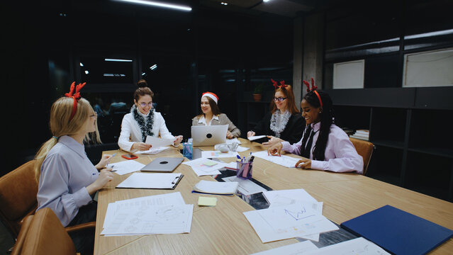 Business women collaborating in a festive office environment in the evening before Christmas holidays