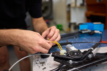 Mechanic fixing vehicle door parts, Closeup of technician repairing car interior components, Professional worker servicing vehicle door with detailed focus and tools