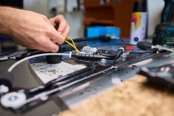 Mechanic fixing vehicle door parts, Closeup of technician repairing car interior components, Professional worker servicing vehicle door with detailed focus and tools