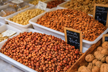 Shelled hazelnuts and almonds on a stand at a farmers market in Nice, France