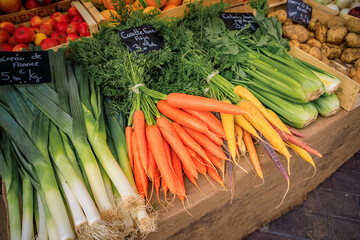 Leeks, carrots and celery tops at a stand at the farmers market in Nice, France