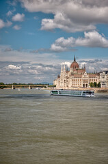 Budapest, Hungary – July 27, 2025: River cruise ship sailing along the Danube with the Hungarian Parliament Building in the background, showcasing scenic travel and architecture under a bright sky