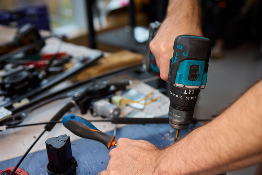 Focused technician conducts precise motor repairs, Dedicated technician methodically finetunes small motor assembly with specialized tools in workshop environment