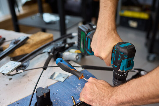 Focused technician conducts precise motor repairs, Dedicated technician methodically finetunes small motor assembly with specialized tools in workshop environment