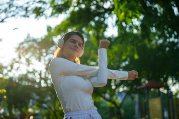 Happy young woman enjoying morning sunlight during outdoor exercise in nature