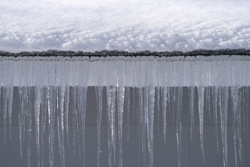 winter house with icicle and snow on the roof